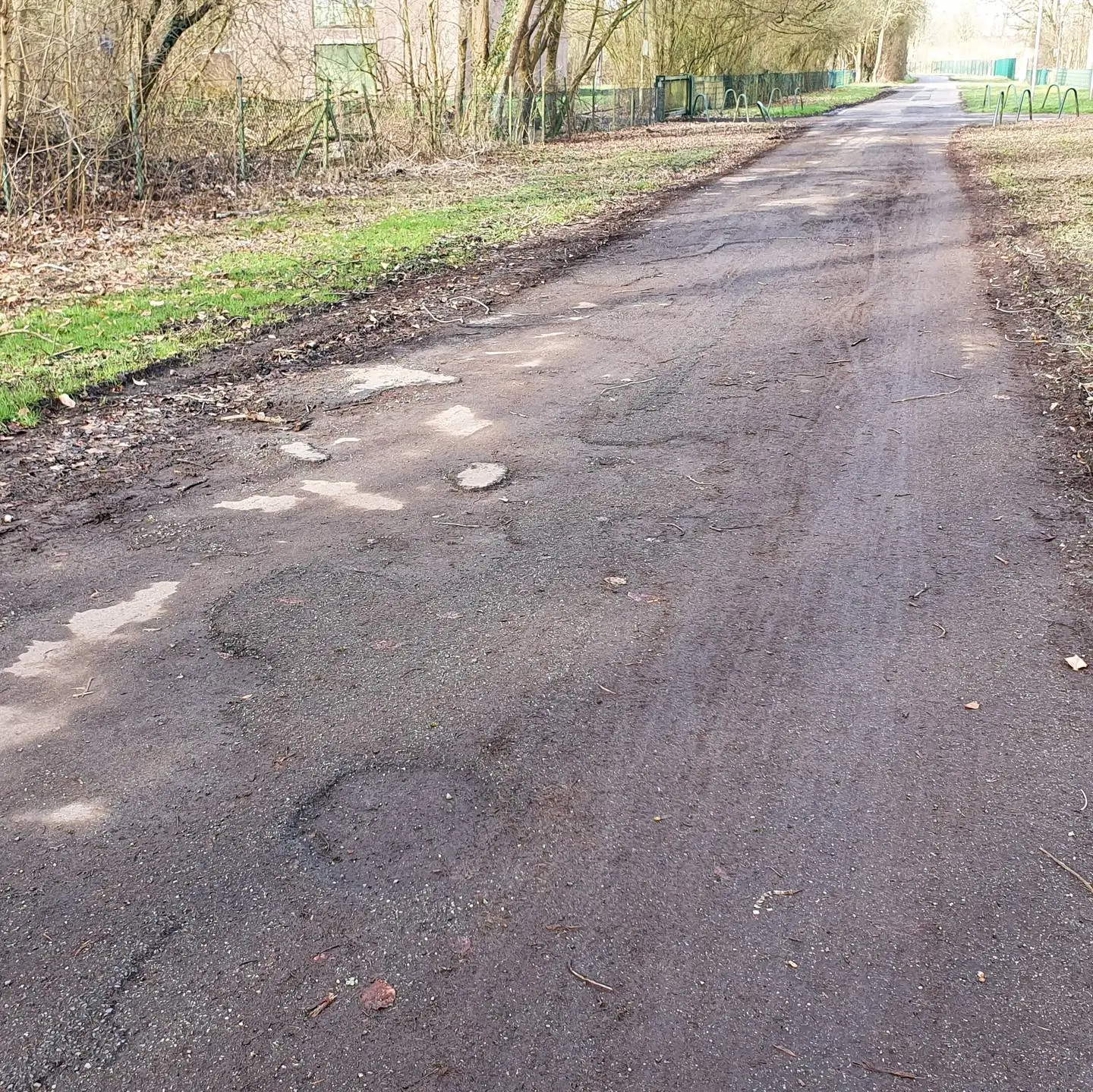 Blick auf den Asphalt der Straße "in der Elt" mit seinen Schlaglöchern und Unebenheiten