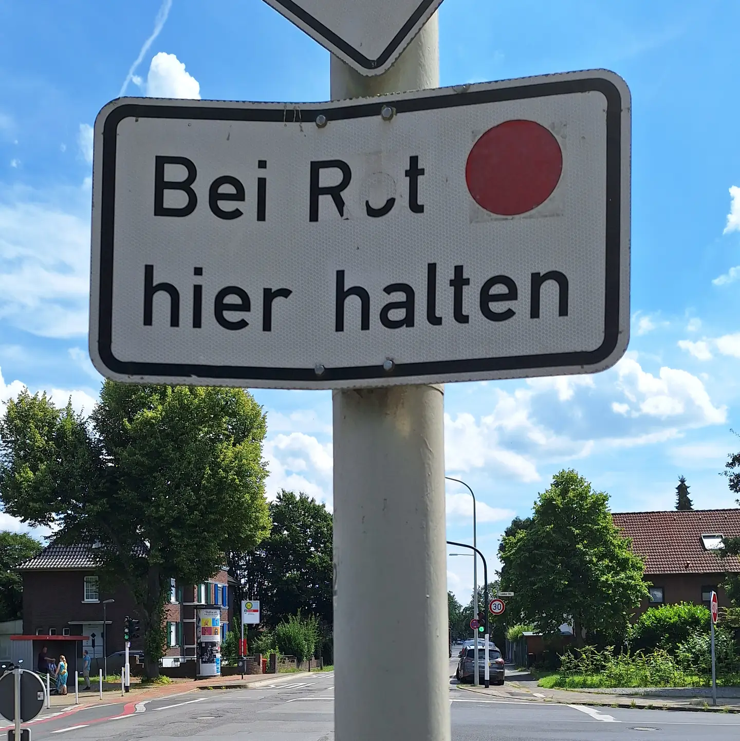 Straße,
 mit Verkehrsschild,
 dass man bei Rot HIER halten muss