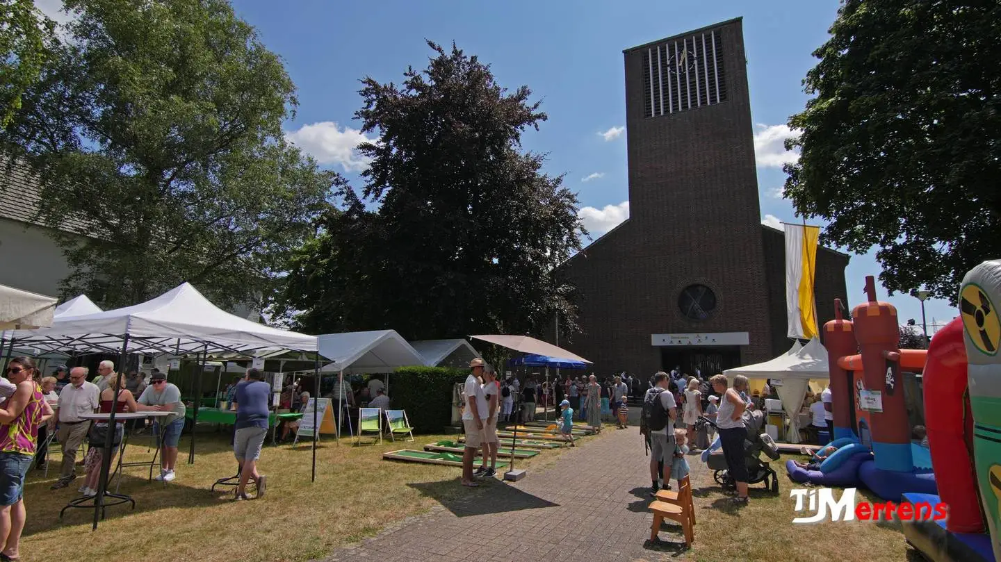 Ansicht von der Straße aus auf die Kirche,
 mit den Ständen und Aufbauten zum Kirchweihfest 2025